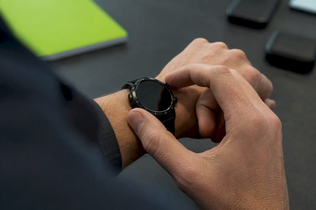 Hand pressing button on smartwatch off screen