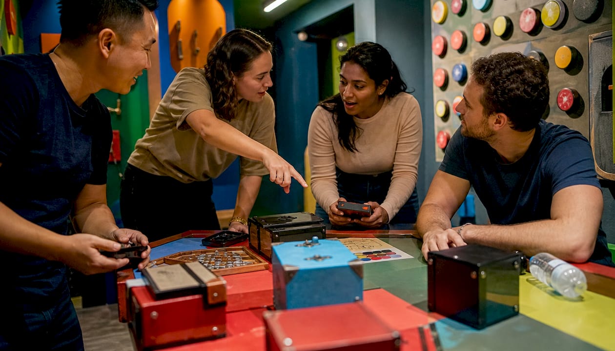 Team members collaborating on escape room puzzle