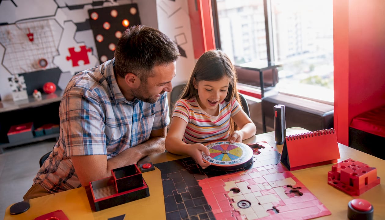 Father helping daughter with escape room puzzle