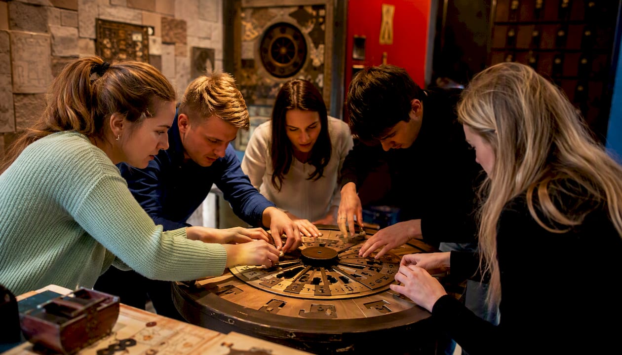 Hands collaborating on escape room puzzle