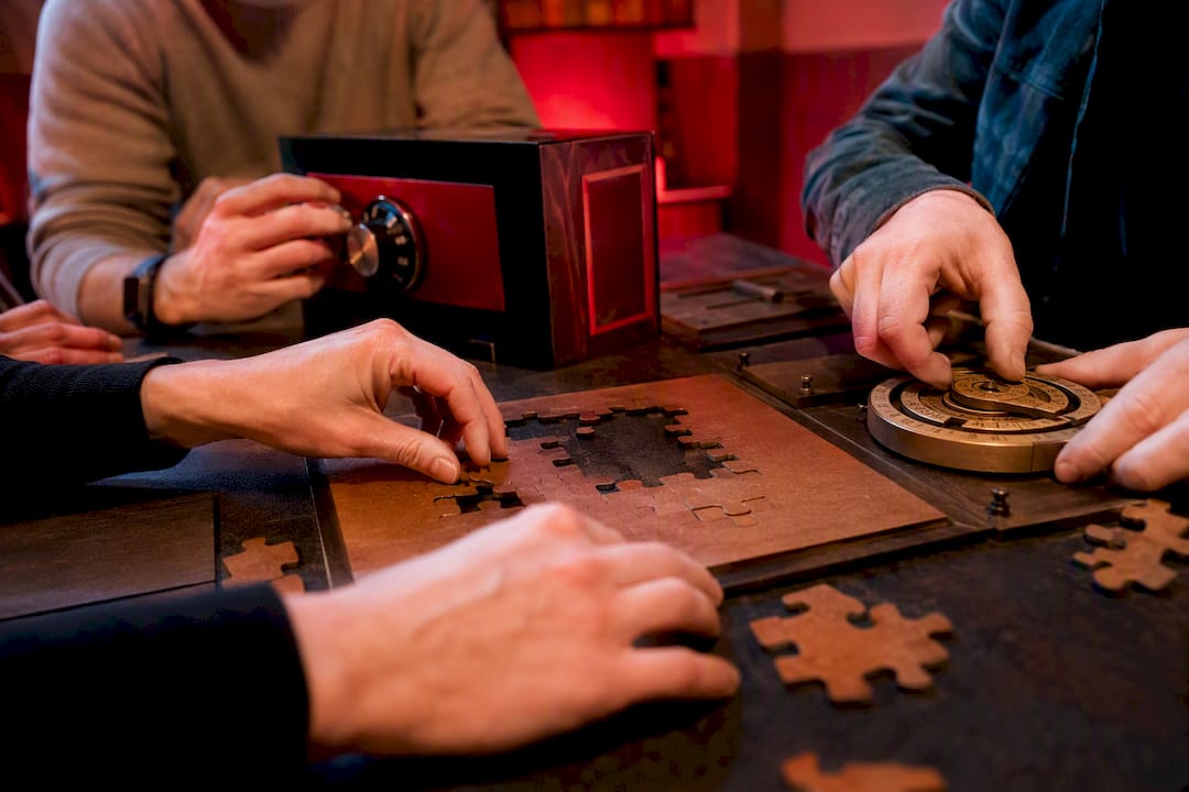 Multiple hands solving different escape room puzzles