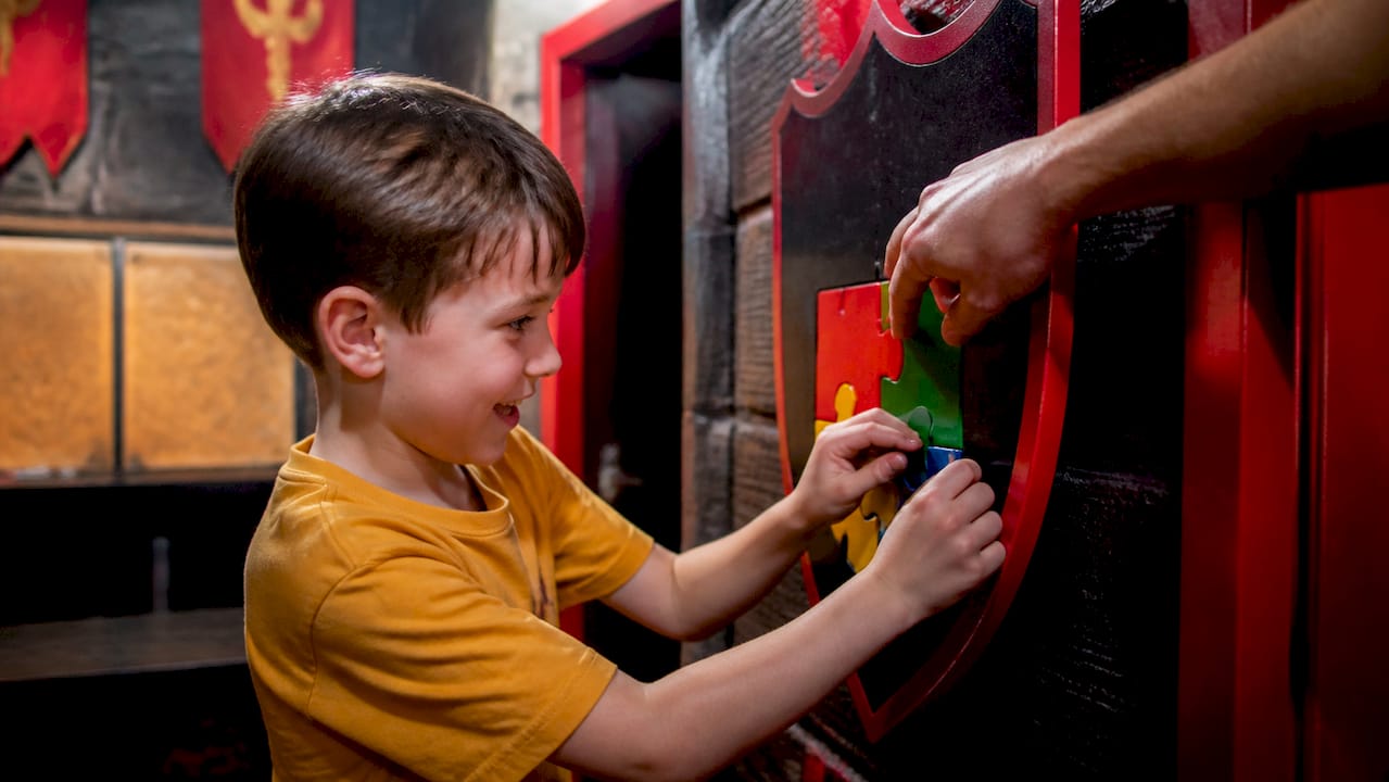 Child solving lock with adult guidance