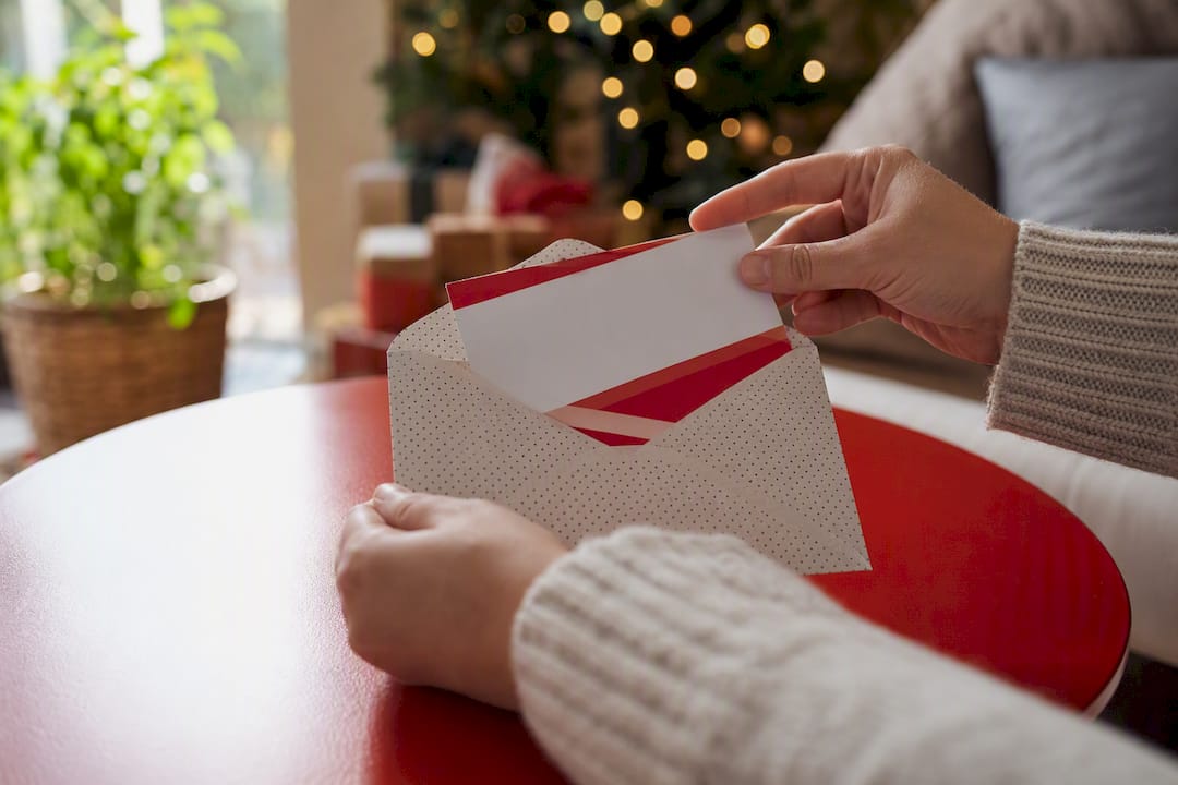 Hands placing escape room voucher into envelope