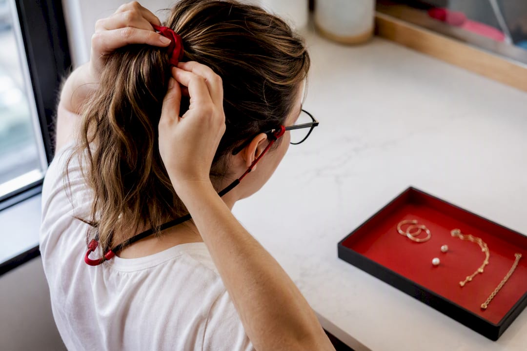 Guest securing glasses and tying back hair