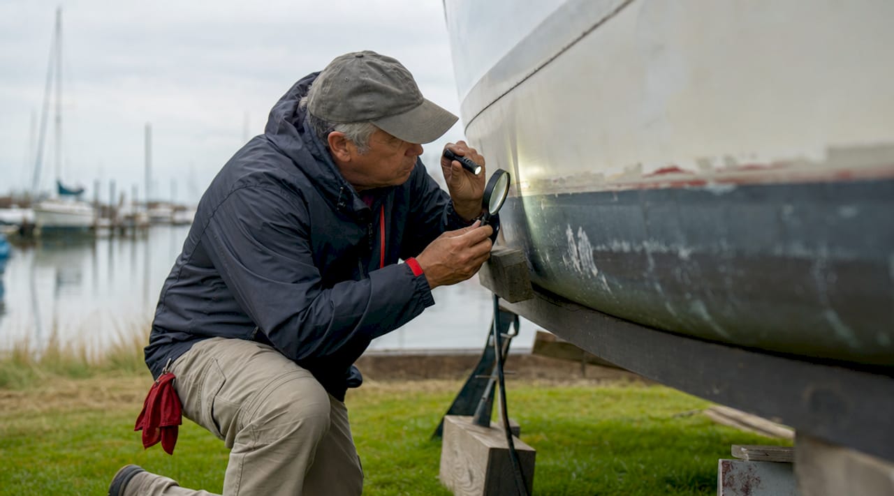 Close-up of hands inspecting boat's HIN stamp