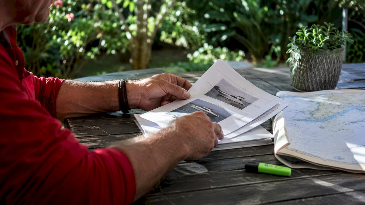 Hands holding vessel license documents at table