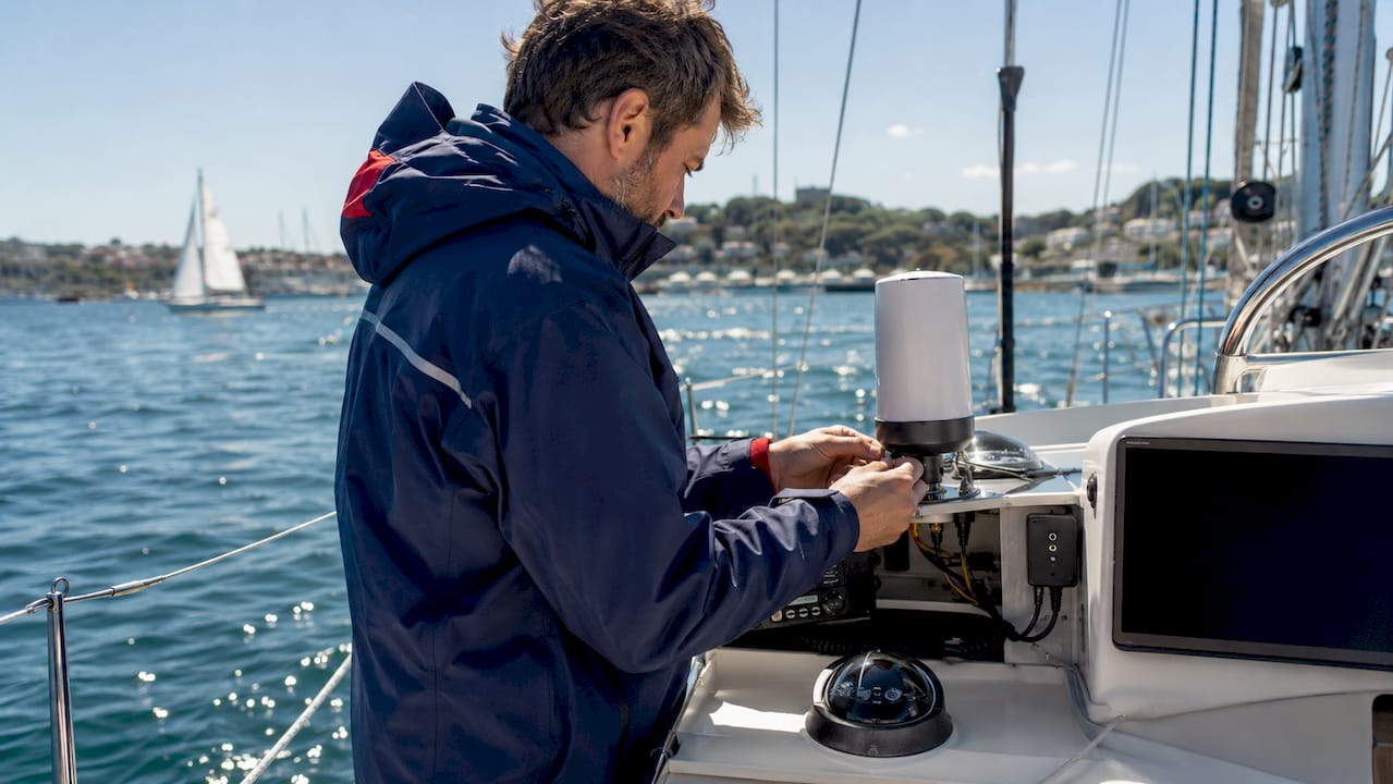Hands adjusting AIS Class B transponder on boat console
