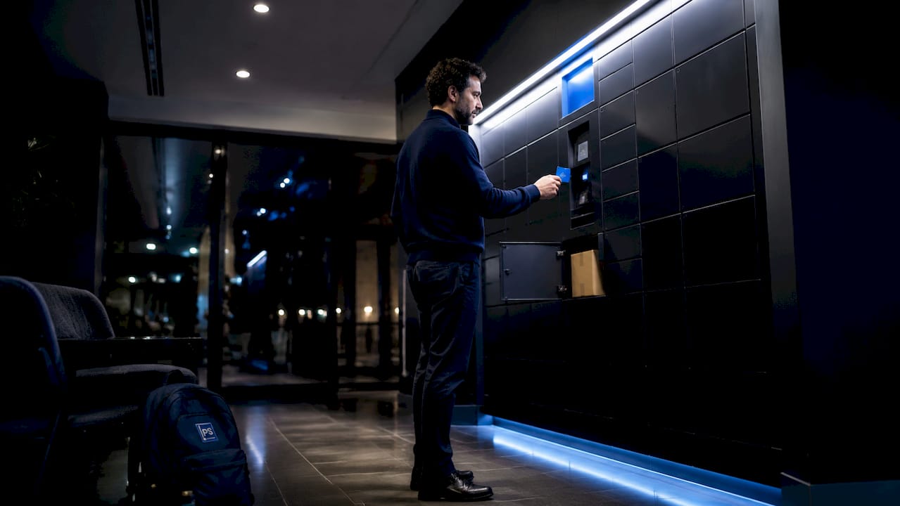Resident accessing electronic parcel lockers in apartment lobby