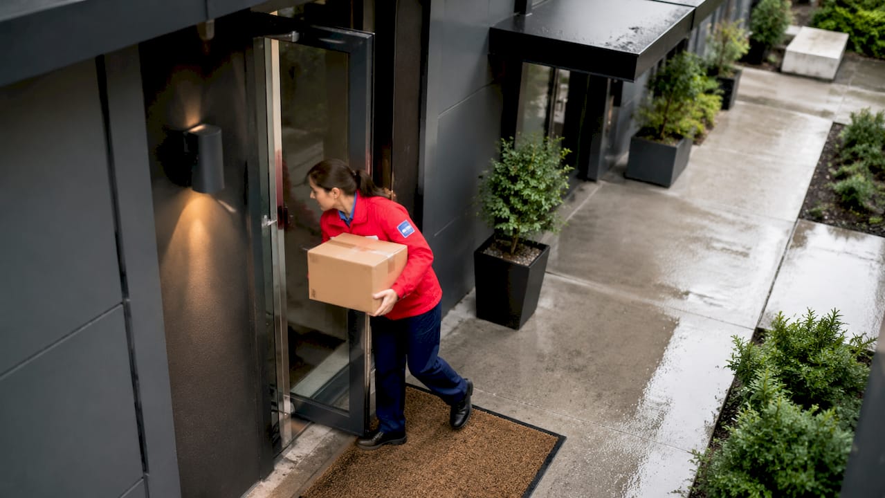 Carrier delivering parcel at apartment entrance