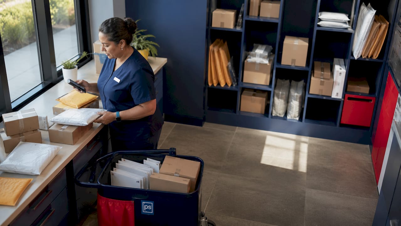 Courier labeling packages in apartment package room