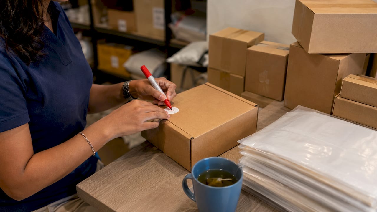 Hands labeling packages for compliance