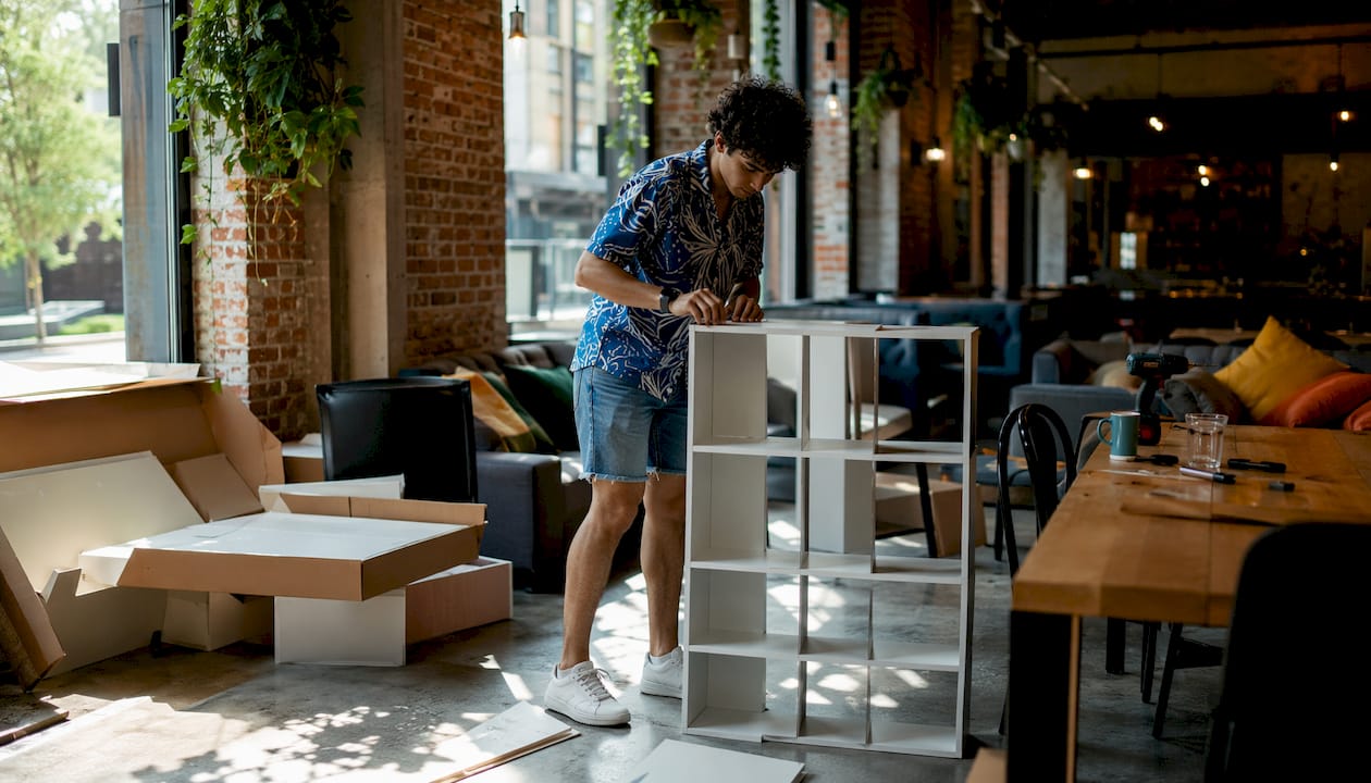 Person assembling modular storage shelf at home