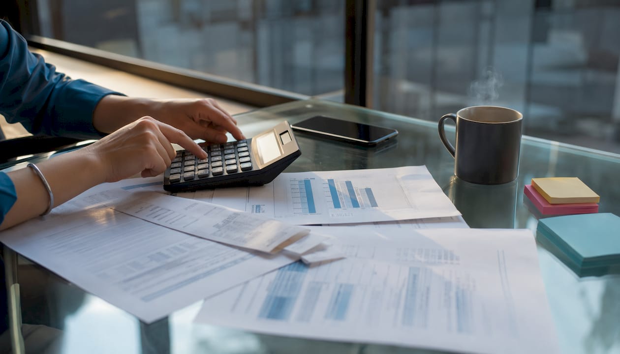 Overhead of hands using calculator for locker CapEx