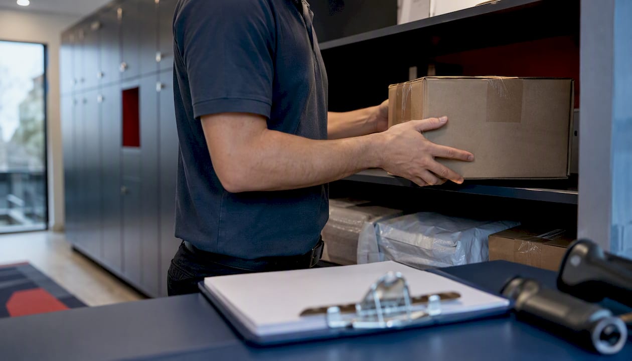 Organized multifamily package room with attendant placing a parcel