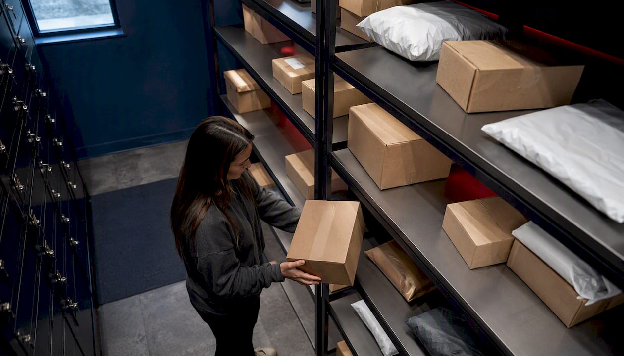 Hands organizing packages in a multifamily package room