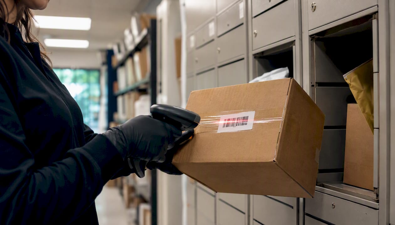 Hands scanning parcel barcode in senior package room