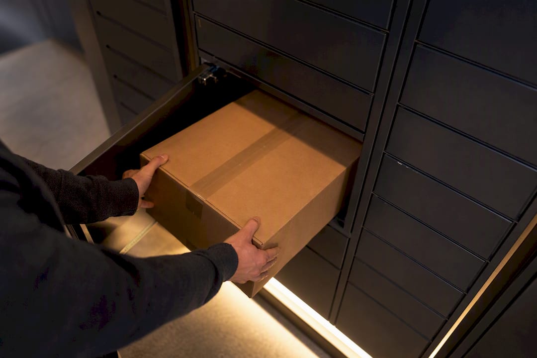 Hands placing package in apartment locker