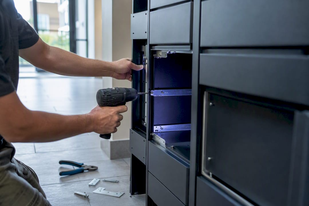 Hands installing package locker panel