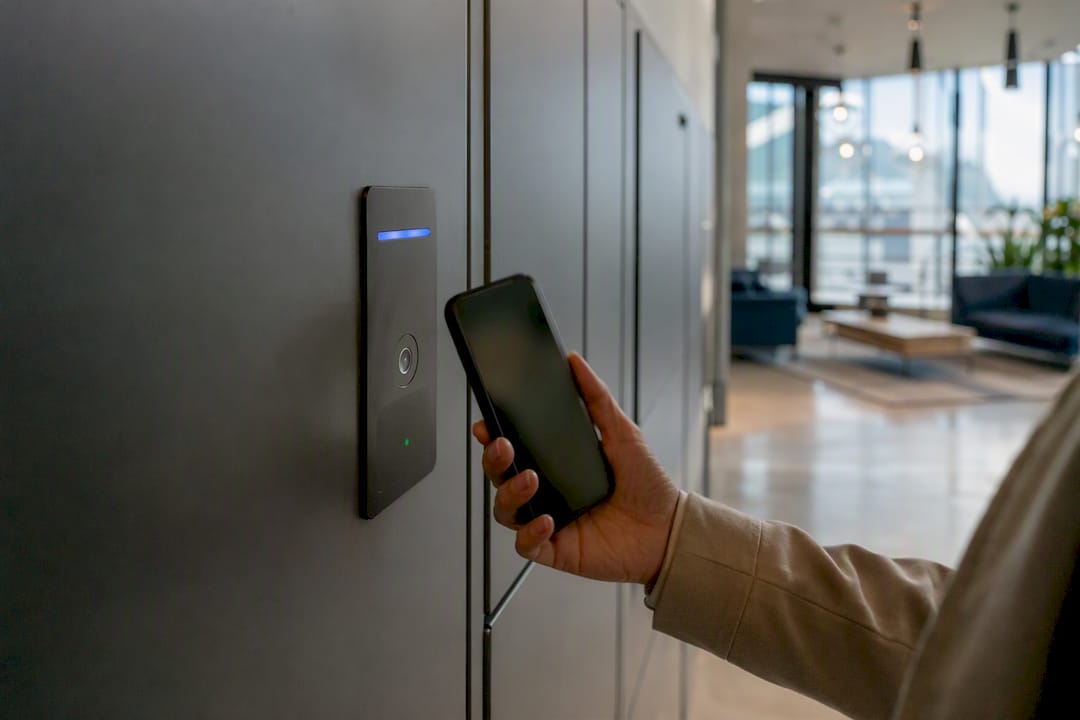 Hand holding smartphone near locker lock