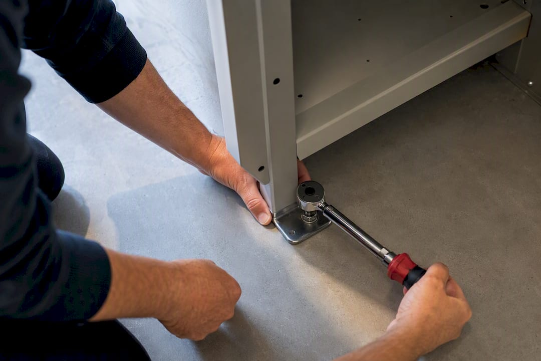 Technician securing locker base anchor