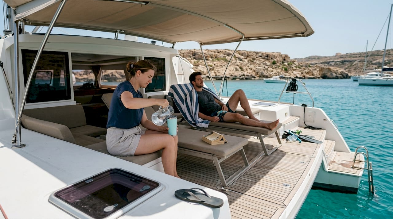 Catamaran deck with guests relaxing near Malta