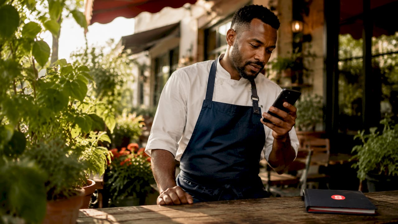 Chef répondant à un avis client sur son téléphone