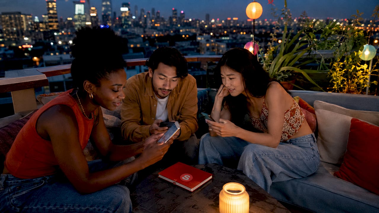 Groupe consultant des avis de restaurant sur des smartphones à l'extérieur
