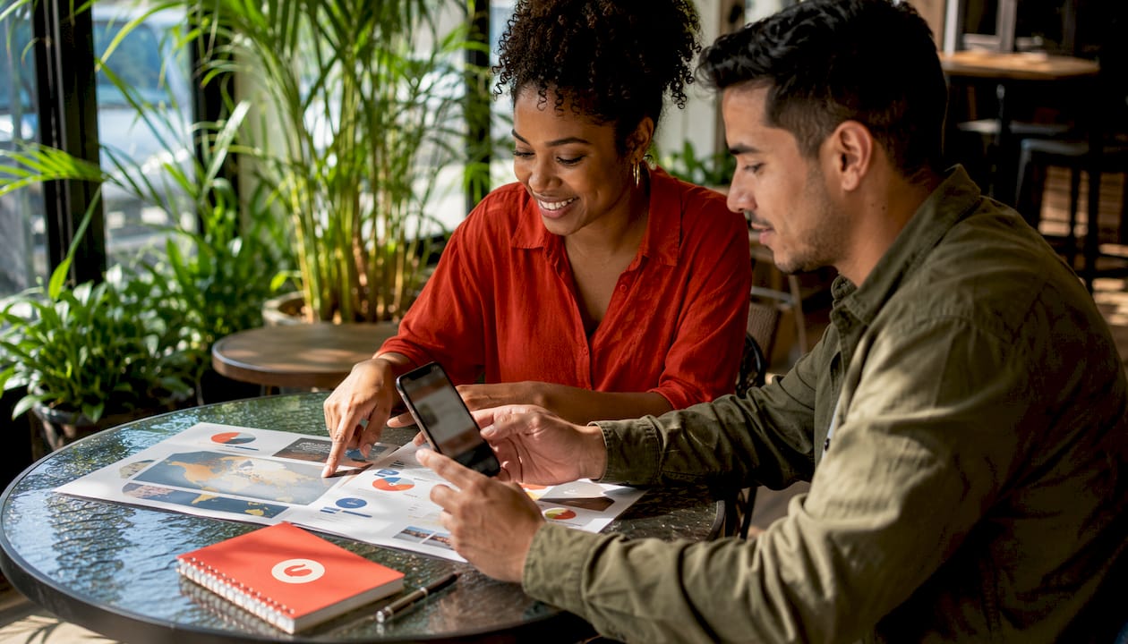 Des mains utilisant des outils de marketing mobile sur un bureau