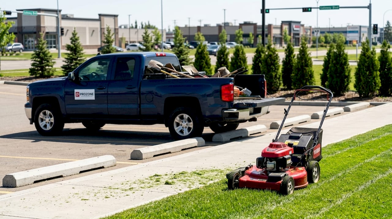 Groundskeeper mowing commercial property lawn