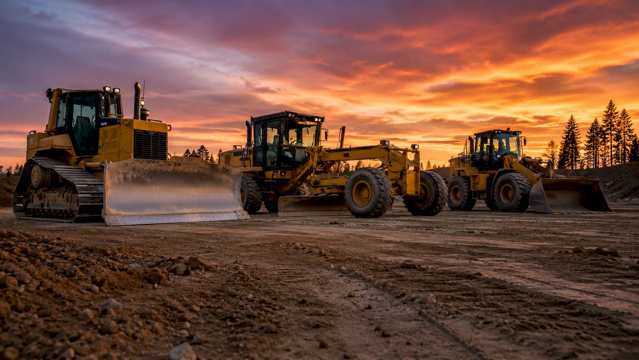Multiple earthmoving machines lined up on construction site