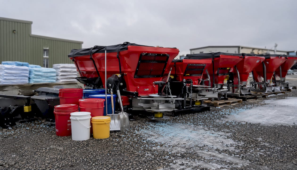 Ice melt spreaders and salt containers on commercial yard floor