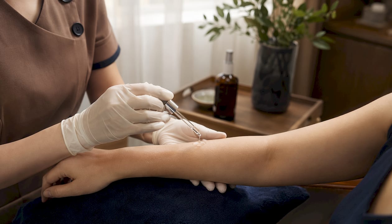 Dermatologist applying serum on patient skin