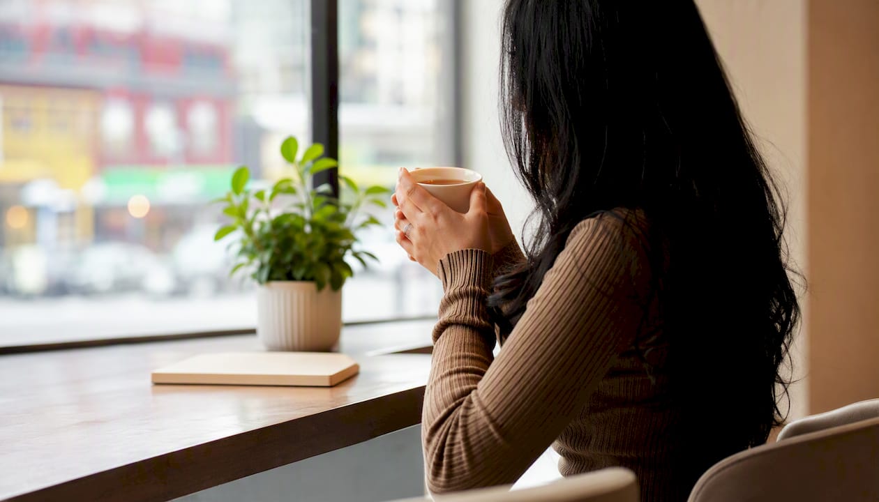 Person holding tea contemplatively in calm room