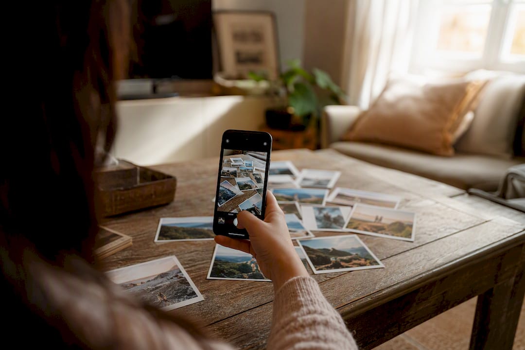 Hand snapping photo of printed pictures for checking