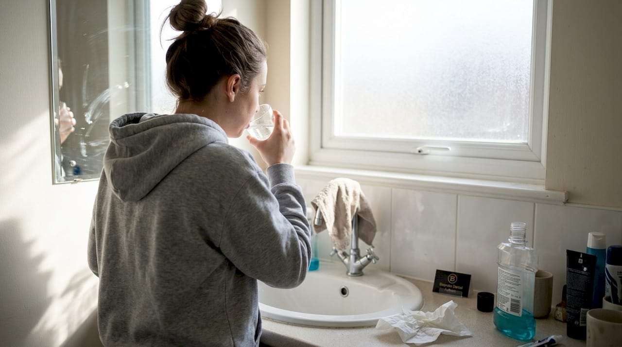 Woman caring for mouth after dental extraction