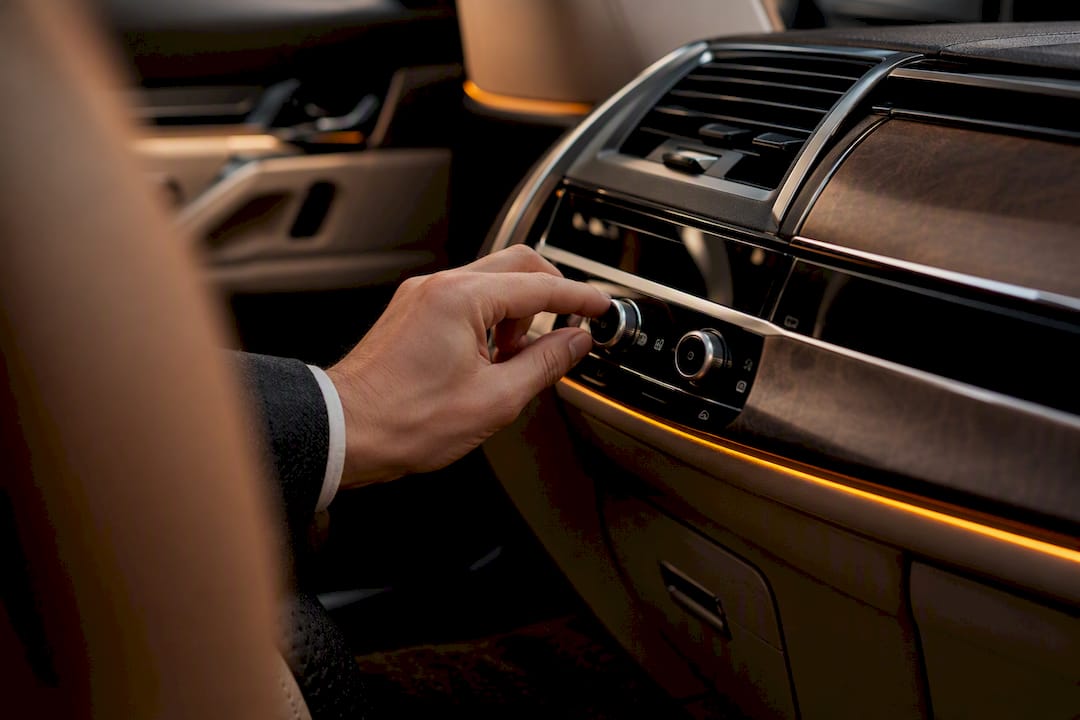 Hand adjusting luxury vehicle climate controls