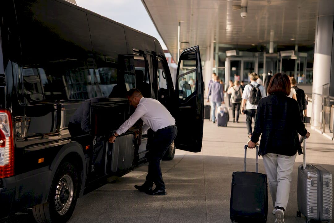 Shuttle bus loading luggage at airport terminal