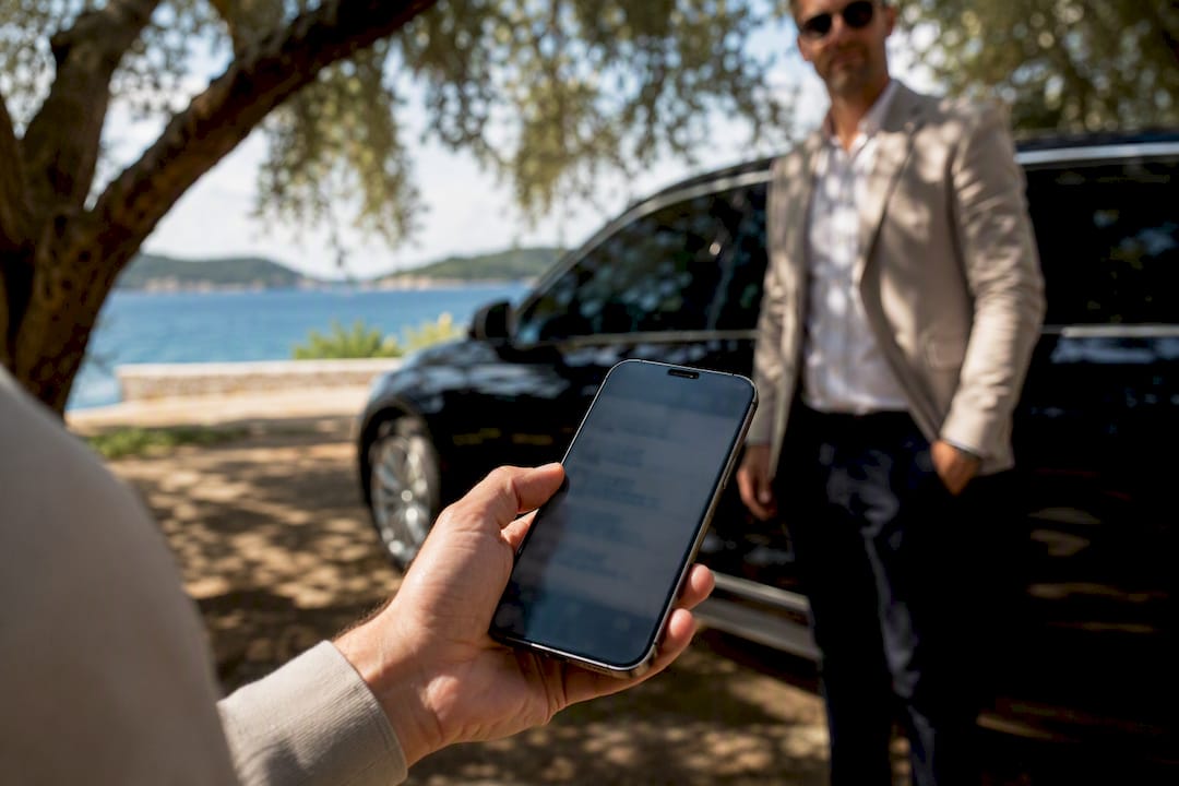 Traveler viewing itinerary on phone near driver