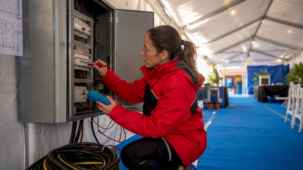 Engineer testing distribution board circuit breakers