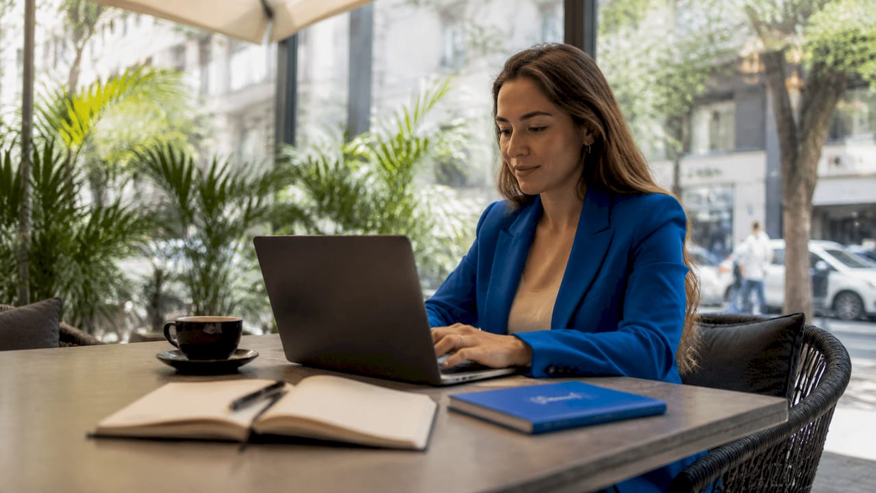 Eine junge Frau erstellt am Laptop Werbeanzeigen für Facebook.