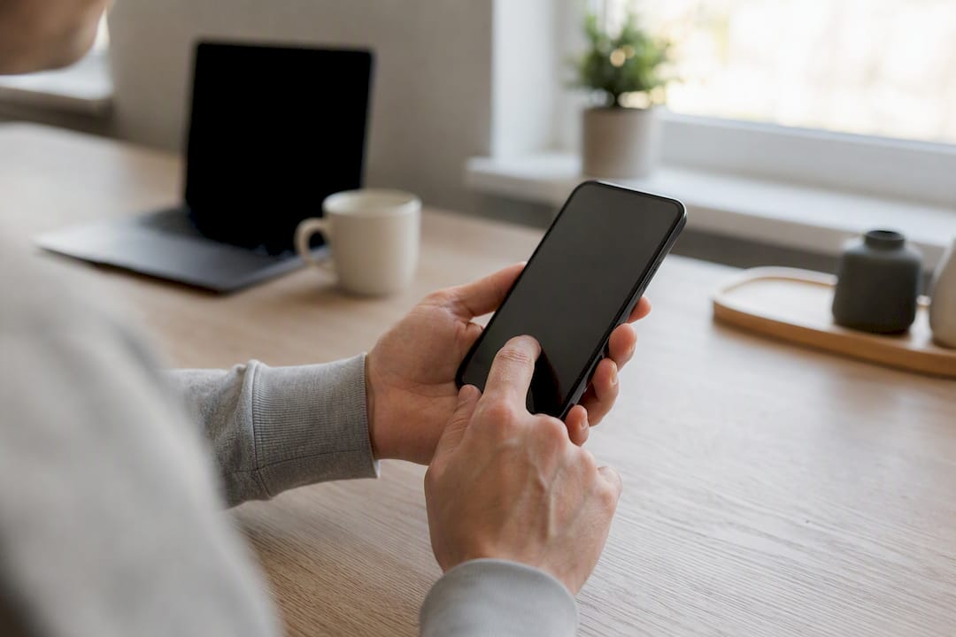 Jemand prüft auf dem Smartphone, wie man eine Online-Bestellung zurückschicken kann.