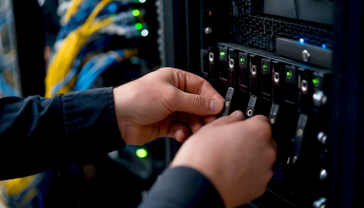 Hands handling hardware security key in server room