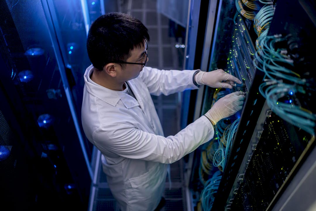 Technician managing cables in data center aisle