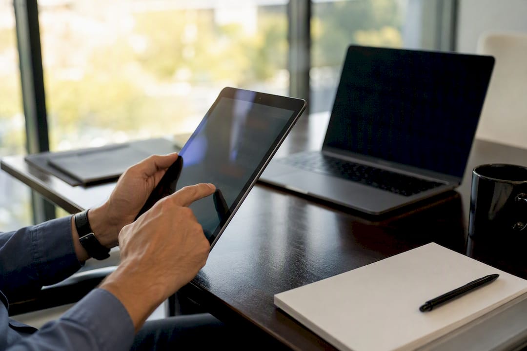 Hands preparing disaster recovery runbooks on tablet
