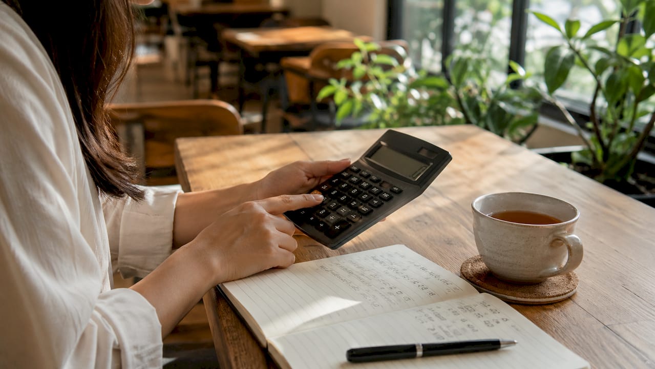 Hands typing and calculating monthly loan repayment
