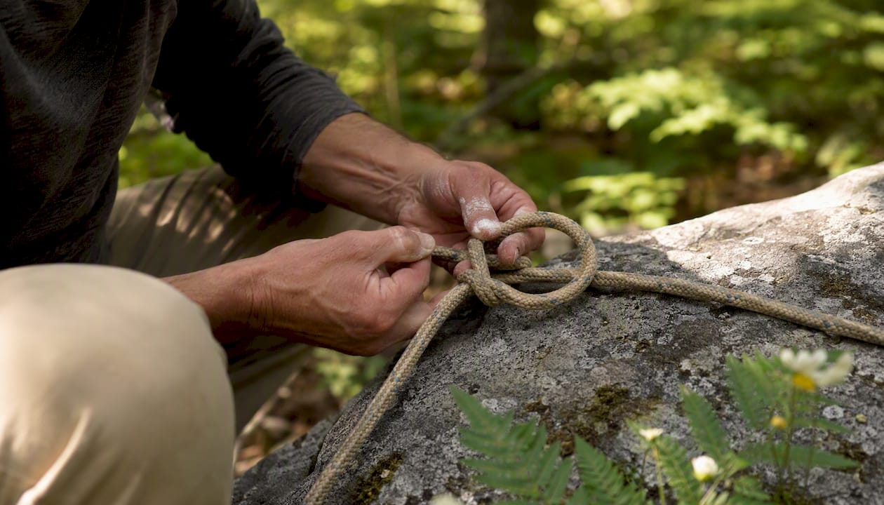 Hands tying bowline knot on outdoor rope