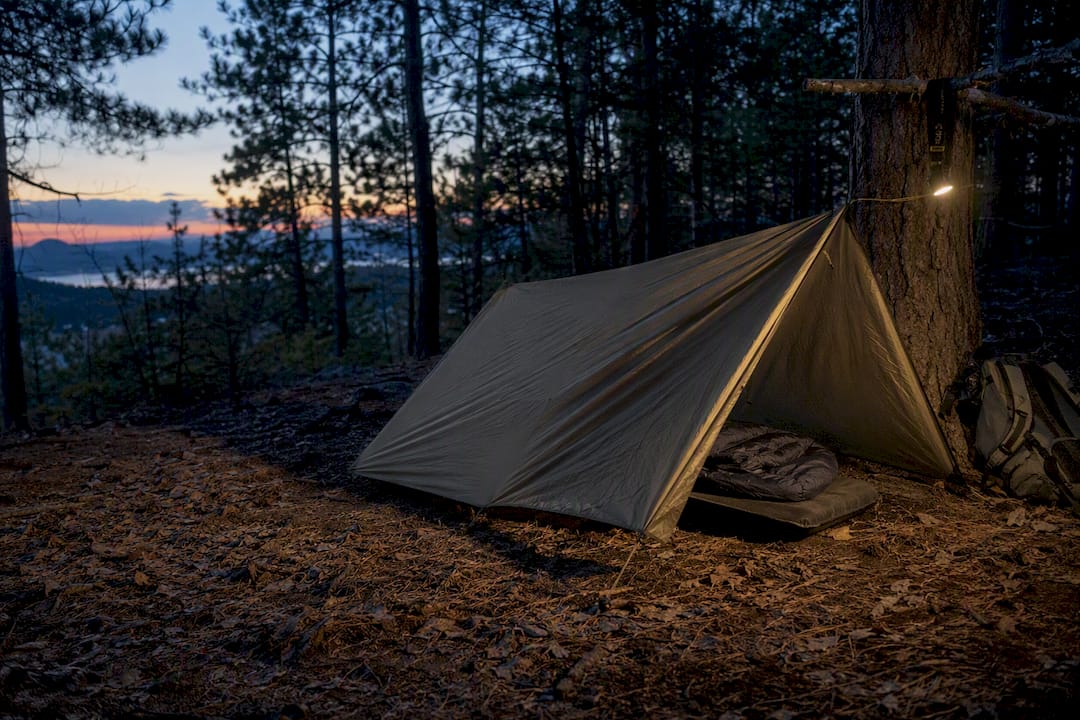 Tarp bivouac shelter setup in forest