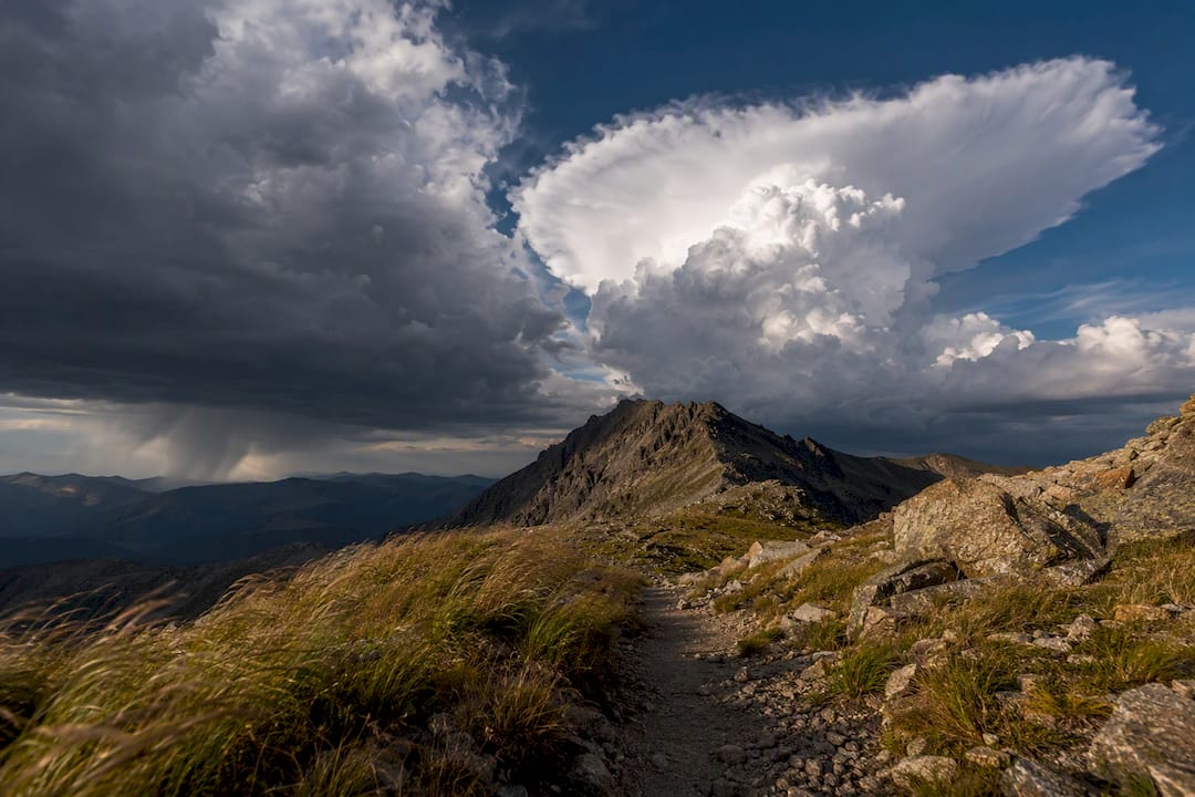 Anvil cloud building over mountain pass