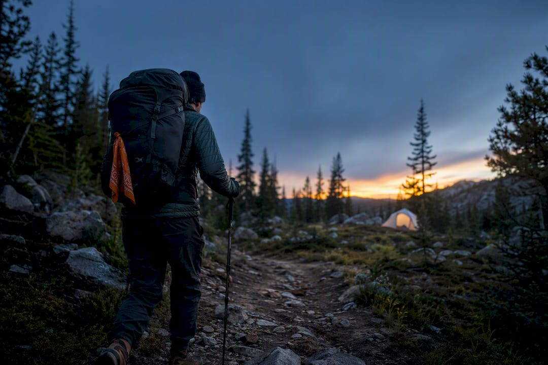 Hiker walking toward a backcountry campsite