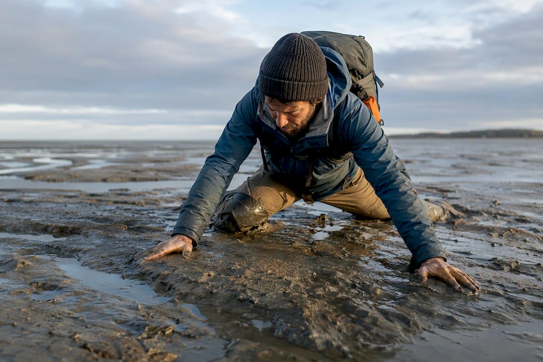 Hiker escaping soft mud on tidal flats
